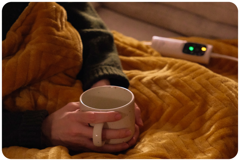 A woman on a sofa with an electric blanket