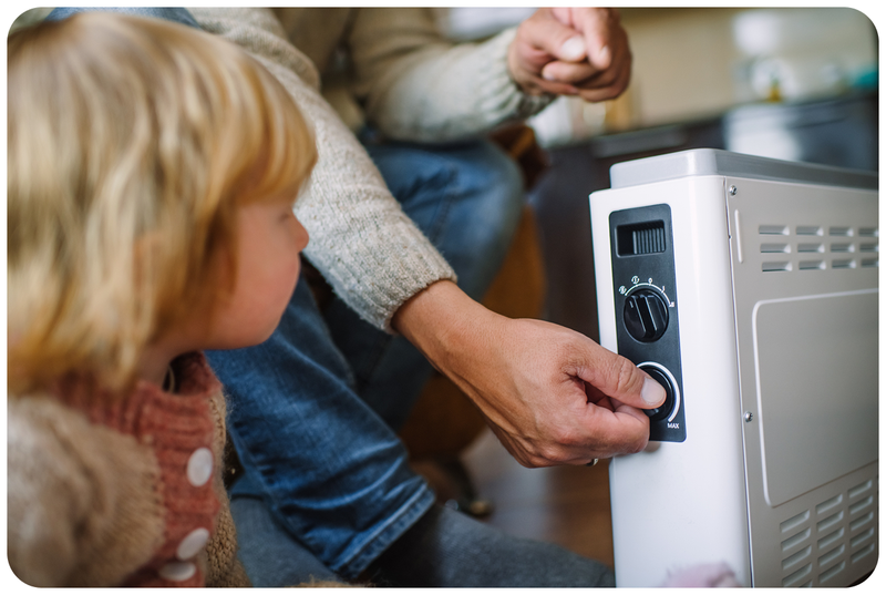 A child looking at a heater with his mum