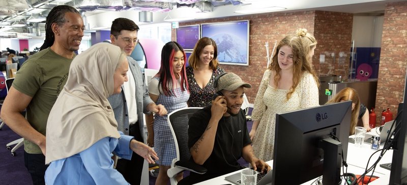 Photo of a group of our energy specialists huddled round a computer