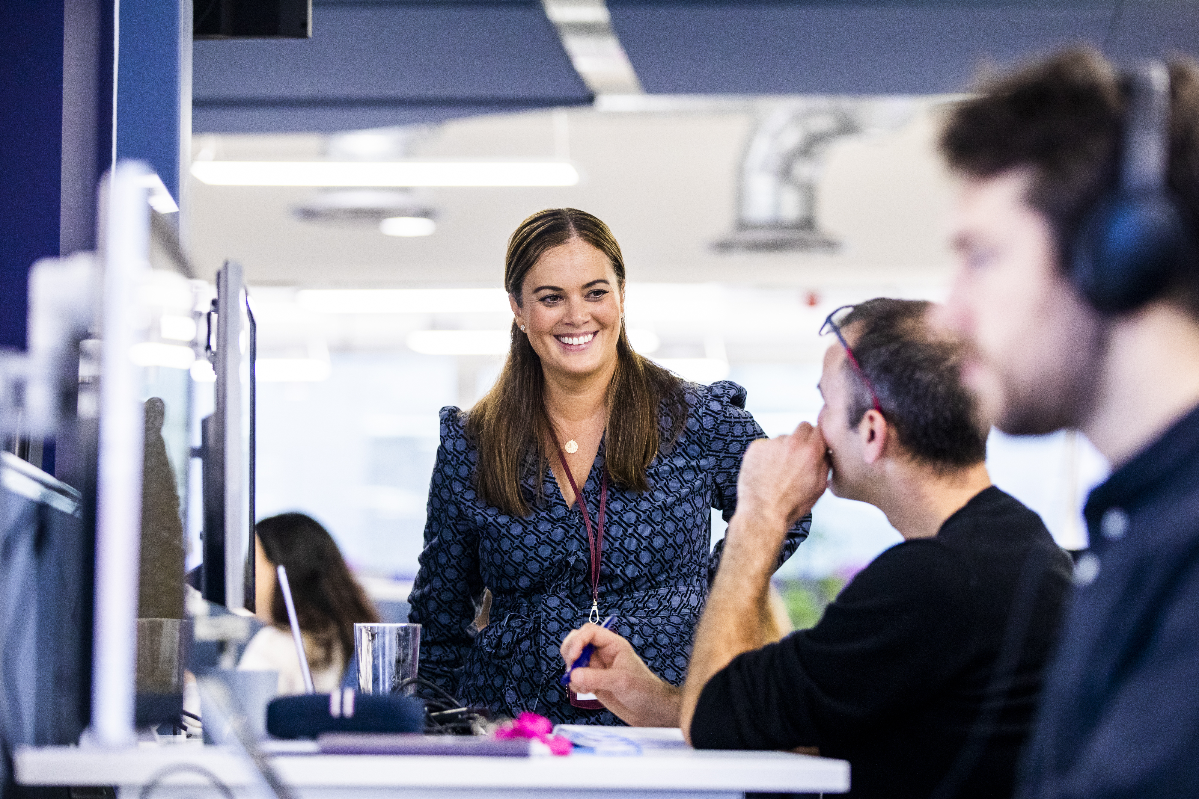 A picture of Zoisa chatting to a team member in the office