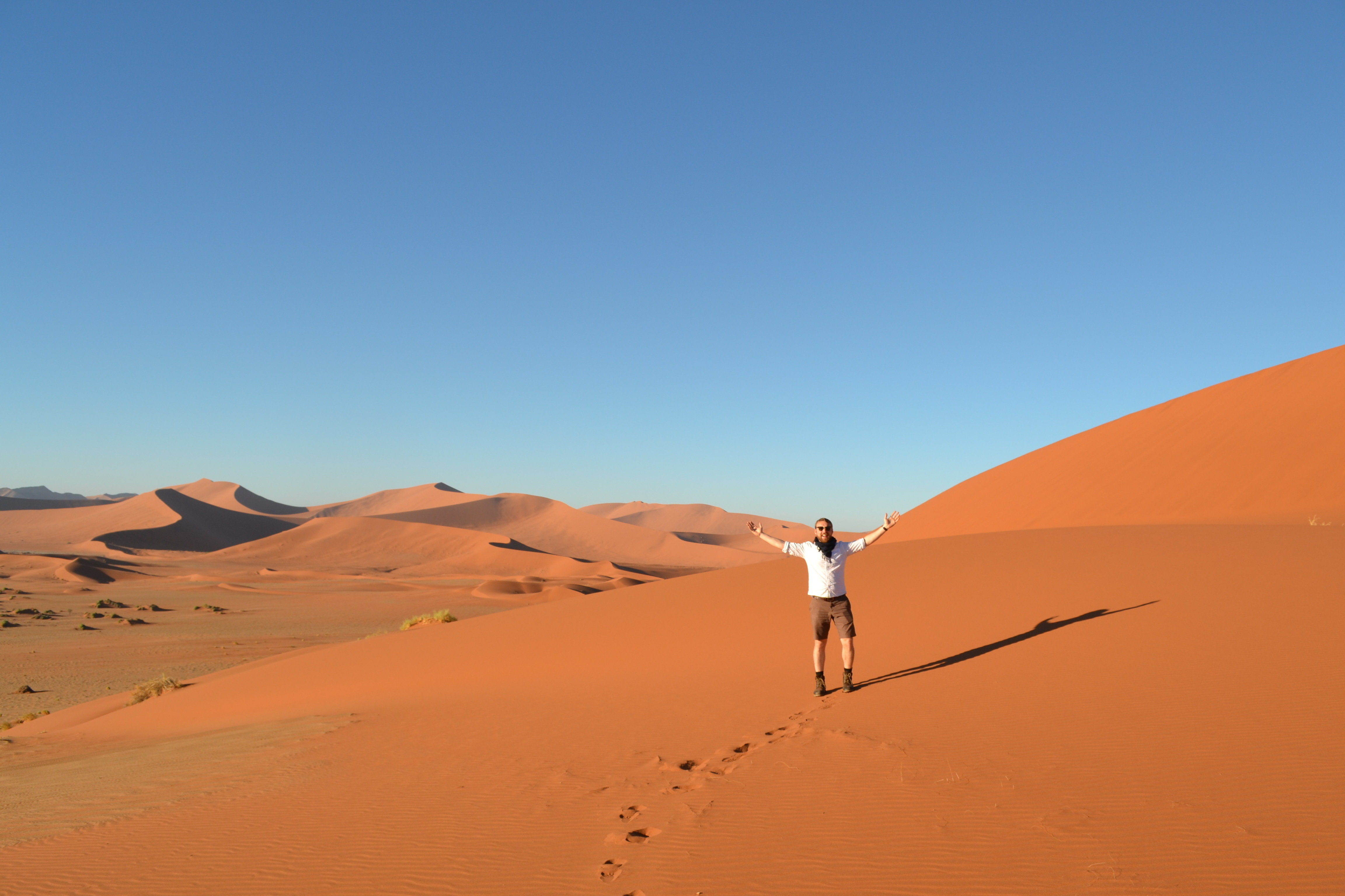 A photo of Alex spreading his arms somewhere in the desert