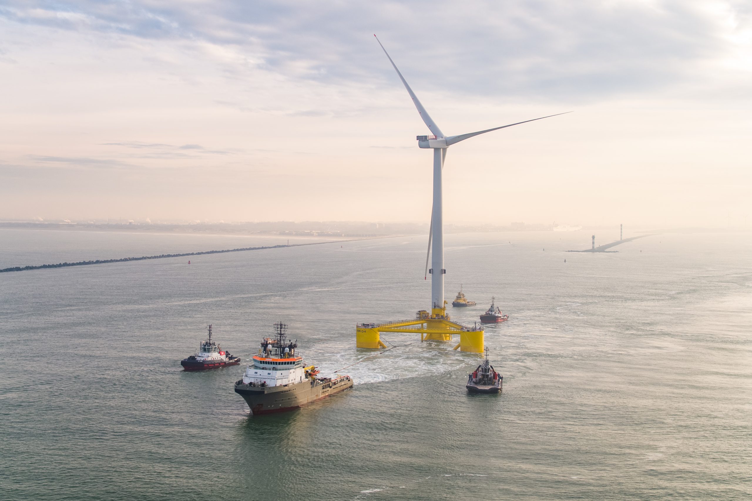 An image of a floating wind turbine being towed out the the wind farm.