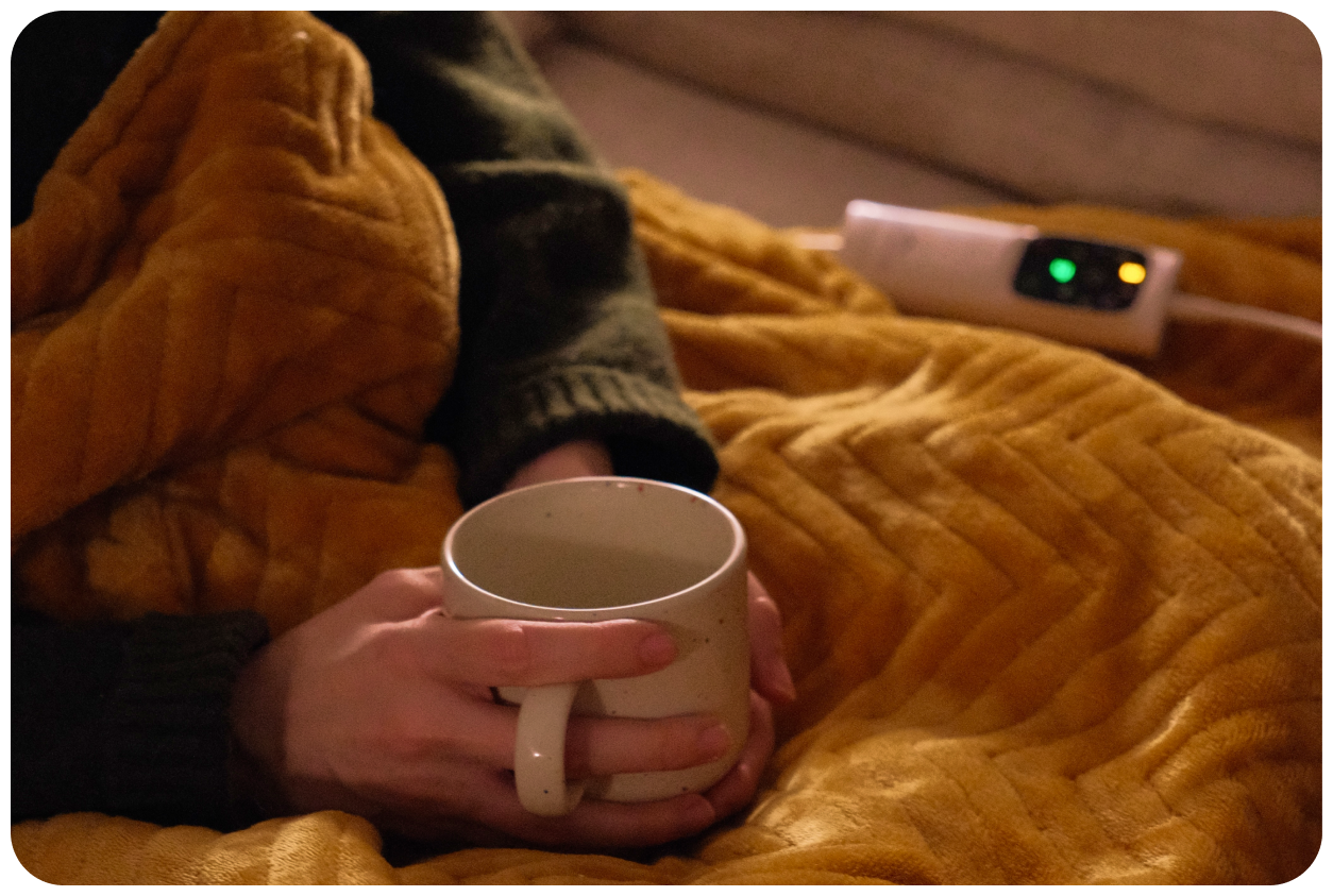 A woman on a sofa with an electric blanket