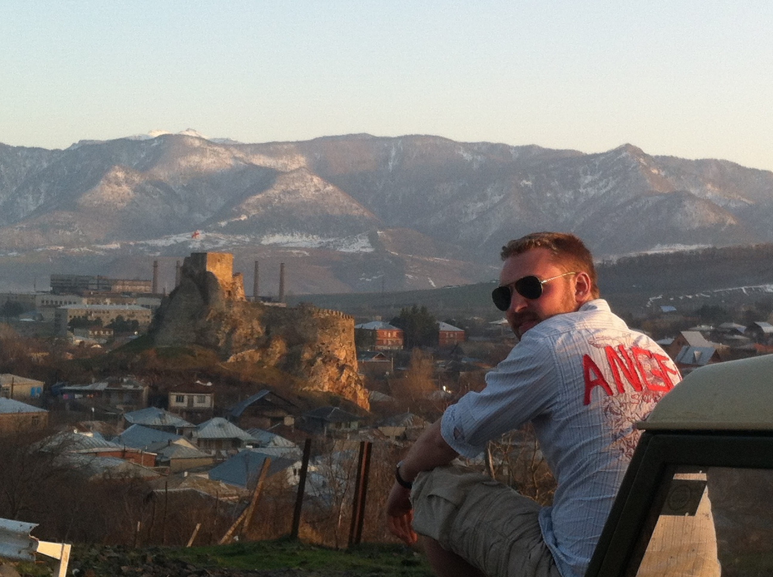 A picture of Alex sitting at dusk, overlooking a city