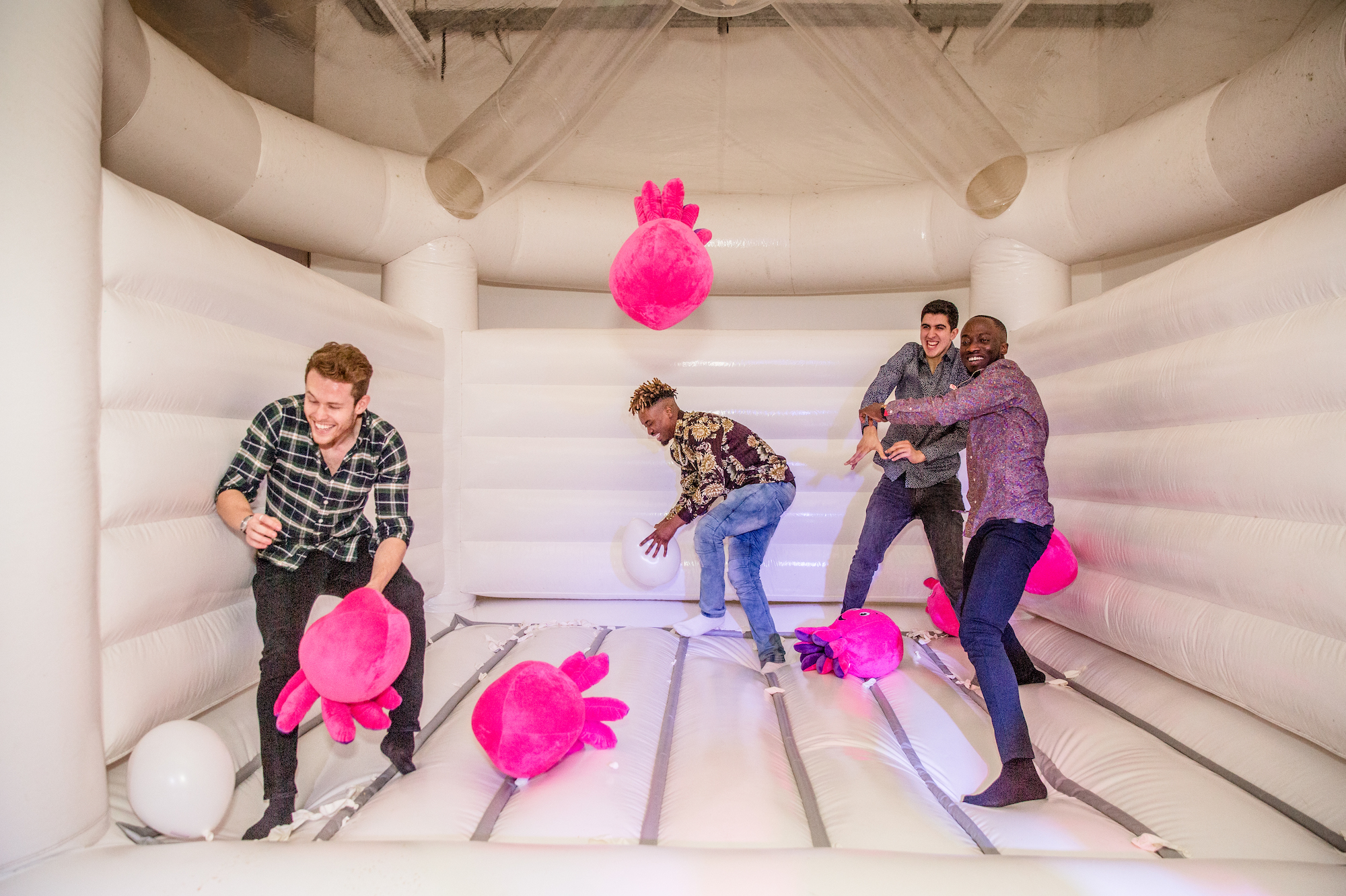 Octopus team members playing on a bouncy castle with fluffy octopus toys