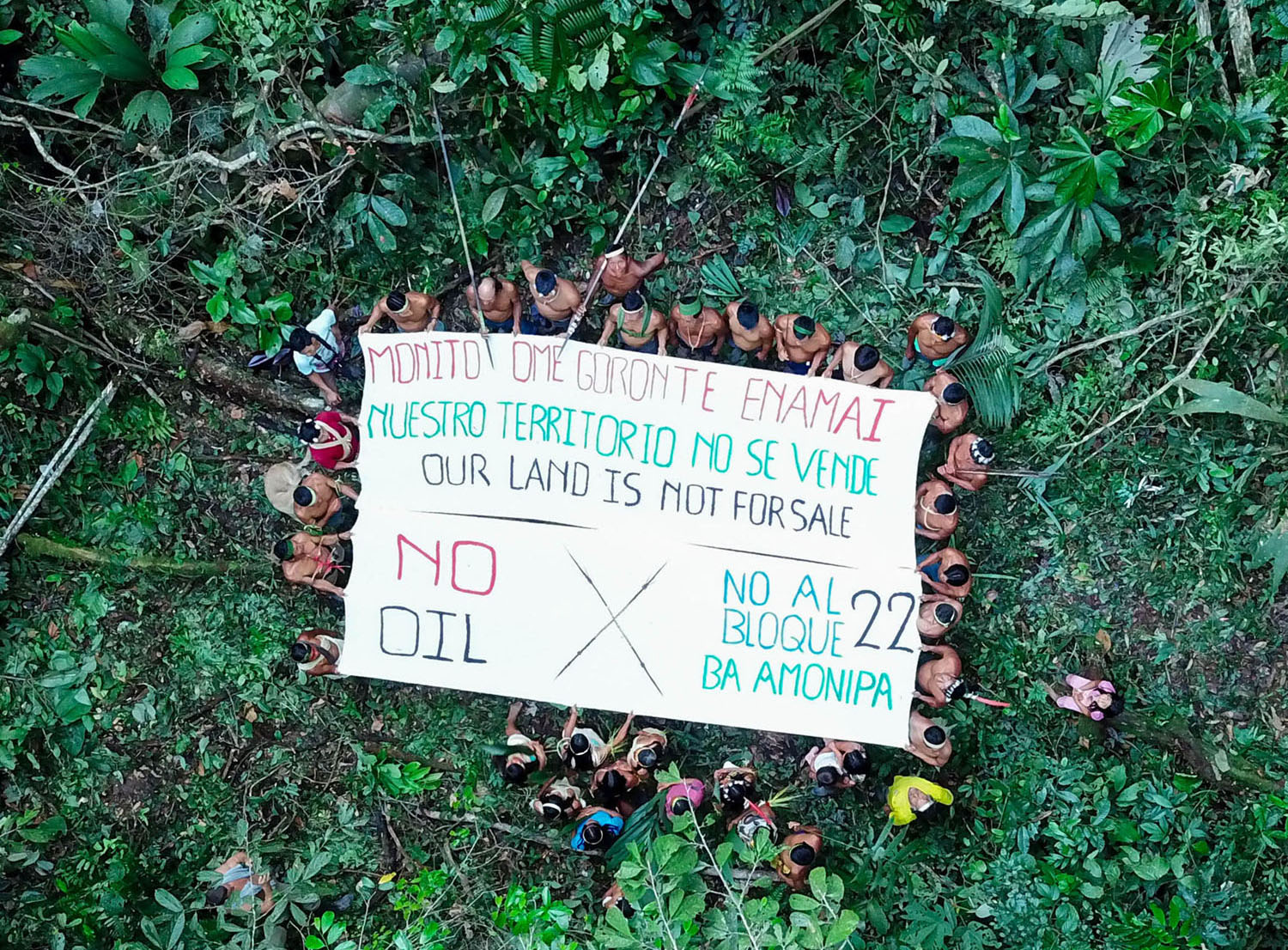 Waorani people hold out a protest banner