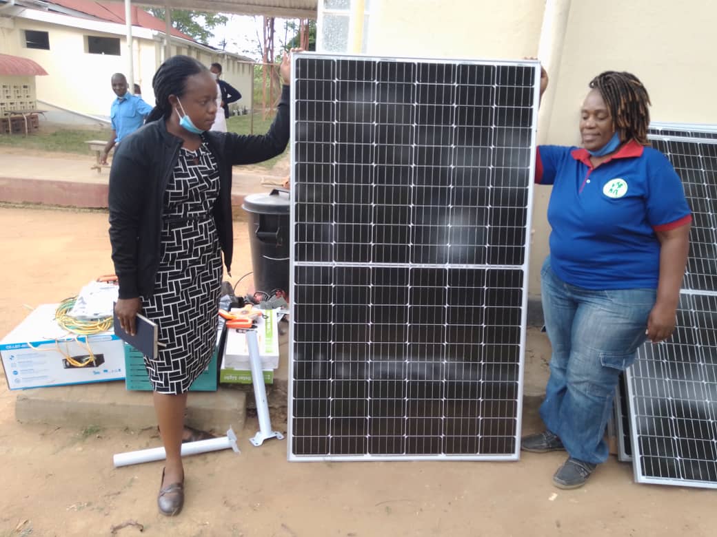 standing next to solar panels at the hospital