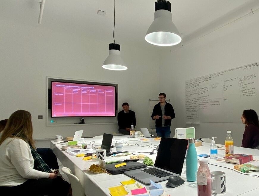 a shot of the podcast creative team in a room working on their content